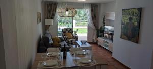 un salon avec une table, des chaises et un canapé dans l'établissement Oasis Hoyo 12 - Oliva Nova playa MET&GOLF, à Oliva