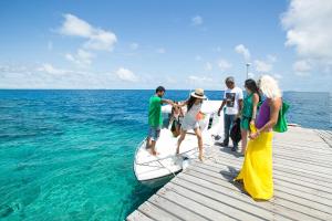 people standing on top of a wooden dock at Stingray Beach Inn in Maafushi