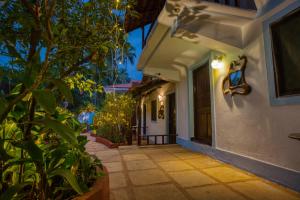 a walkway leading to a house at night at The Funky Monkey Hostel in Anjuna