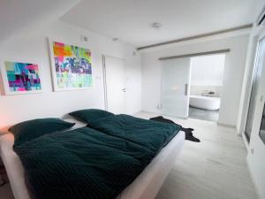 a bedroom with a large bed and a bath room at Villa Dreamy Vibes mit Privatem Pool & Rheinblick in Niederkassel