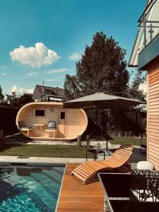 a small boat with an umbrella next to a house at Villa Dreamy Vibes mit Privatem Pool & Rheinblick in Niederkassel