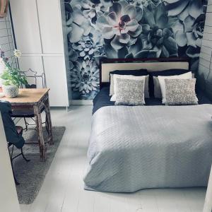 1 dormitorio con 1 cama y una pared con flores en Houseboat Bonnie, en Ámsterdam