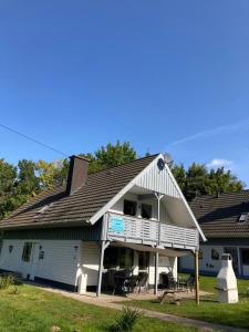 a large white house with a porch and patio at Ferienhaus am Silbersee Leni in Frielendorf