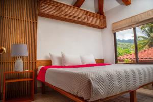 une chambre avec un grand lit avec une fenêtre dans l'établissement Villas Alturas, à Dominical 40 autres photos