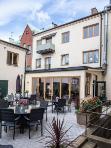 a patio with tables and chairs in front of a building at Stora Hotellet Osby in Osby
