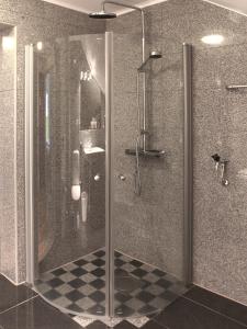 a bathroom with a shower with a glass door at Stora Hotellet Osby in Osby