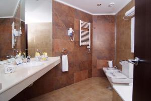 a bathroom with a sink, mirror, and bathtub at Sandos Monaco - Adults Only in Benidorm