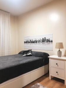 ein Schlafzimmer mit einem Bett und einem Wandgemälde in der Unterkunft Piso en Urbanización Villarchao in O Grove