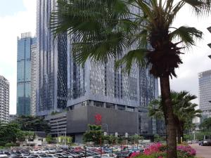 uma palmeira em frente a um edifício com carros estacionados em Star Luxury Suites KLCC em Kuala Lumpur