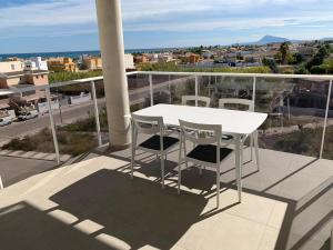Biały stół i krzesła na balkonie w obiekcie Beautiful apartment with pool near the beach w mieście Oliva