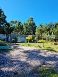 uma entrada de cascalho com uma casa ao fundo em Ohana Punta Ballena cero nueve siete tres uno ocho ocho nueve cinco em Punta del Este