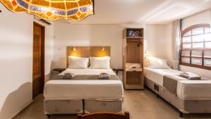 Un dormitorio con dos camas y una lámpara de araña. en Hotel Chalet Monet - Granja Vianna, en Cotia