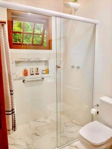 baño con ducha, aseo y ventana en Chalés Alcantilado - Morada Sol e Lua, en Visconde De Maua