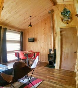 a room with a table and chairs in a cabin at Bajo la Cruz del Sur - Conguillio in Melipeuco