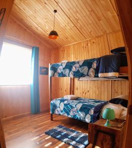 um quarto com um beliche num chalé de madeira em Bajo la Cruz del Sur - Conguillio em Melipeuco