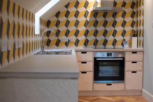 una cocina con papel de pared geométrico amarillo y negro en The Coach House at The Albannach en Lochinver