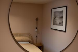 a mirror in a room with a bed and a picture at The Coach House at The Albannach in Lochinver