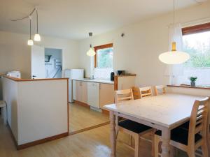 een keuken en eetkamer met een tafel en stoelen bij Holiday home Væggerløse CCXII in Bøtø By