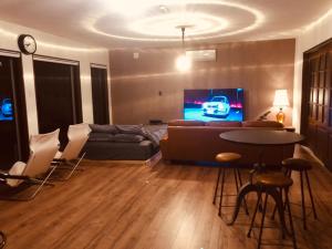 a living room with a couch and a tv at ゴールデンマイルヴィラ in Amami