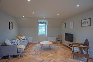 sala de estar con sofá, mesa y TV en The Coach House at The Albannach en Lochinver