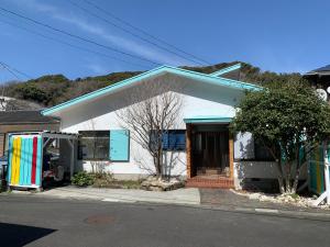 a small white house with a colorful at Kisami Waves Beach House Shimoda in Shimoda