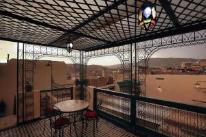 Dar Panoramic Fez في فاس: شرفة مع طاولة وكراسي على شرفة