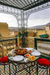 非斯的住宿－Dar Panoramic Fez，阳台上摆放着食物盘的桌子