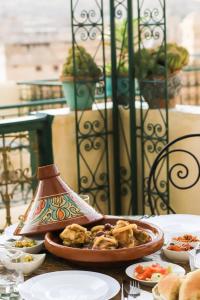 Dar Panoramic Fez في فاس: طاولة مع وعاء من الطعام على طاولة