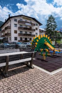 un edificio con parque infantil en un aparcamiento en Albergo Giannina, en Vigo di Cadore