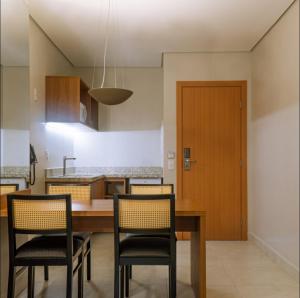 a kitchen with a wooden table and chairs at Salinas Exclusive Resort in Salinópolis