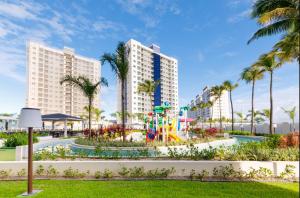 a view of the resort with a playground and palm trees at Salinas Exclusive Resort in Salinópolis