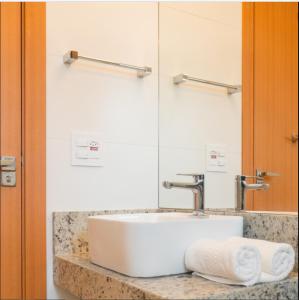 a bathroom with a white sink and a mirror at Salinas Exclusive Resort in Salinópolis