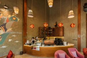 a coffee shop with a woman behind the counter at Sukruethai Hotel Chiang Mai - โรงแรมสุขฤทัย เชียงใหม่ in Chiang Mai