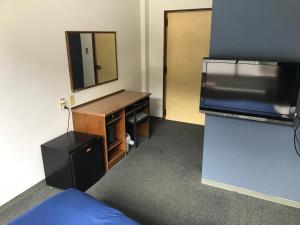 a room with a mirror and a dresser with a dresser at Biz Hotel Kiiyura in Yura