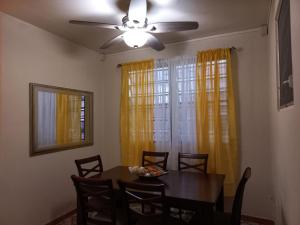 a dining room with a table and a ceiling fan at More Than Beauty Properties in San Juan