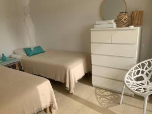 1 dormitorio con 1 cama, vestidor y silla en Prachtig 4 pers. appartement gelegen op Blue Bay!, en Dorp Sint Michiel