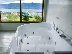 eine weiße Badewanne in einem Badezimmer mit Fenster in der Unterkunft Glamping sede campestre Mirador de Pueblo Viejo in Guatavita