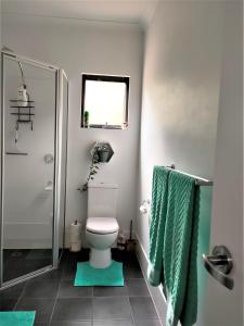 baño con aseo y toalla verde en Warren Retreat - cozy and tranquil 2 brm home, en Nannup