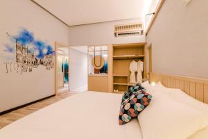 1 dormitorio con 1 cama blanca grande en una habitación en Tien Hotel Georgetown en George Town