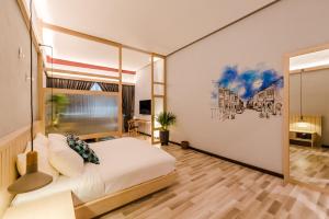 Un dormitorio con una cama blanca y una pintura en la pared en Tien Hotel Georgetown, en George Town