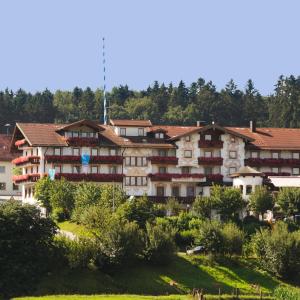 a building on a hill with trees in the background at Hotel-Gasthof Huber in Ebersberg