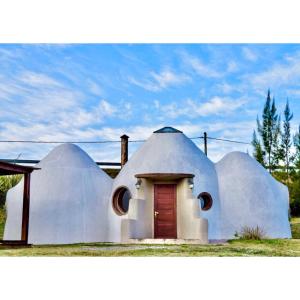 uma casa de cúpula branca com uma porta vermelha em Valle de Domos - Minas em Minas
