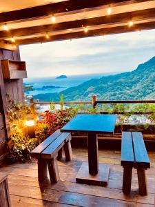 a picnic table on a deck with a view at Winsor's Han-Guan in Jiufen