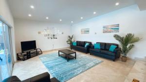 ein Wohnzimmer mit Sofa und Fernseher in der Unterkunft Pool Villa in Miami