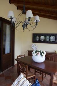a room with a table with a vase of flowers on it at I Giardini di San Vito lo Capo in San Vito lo Capo