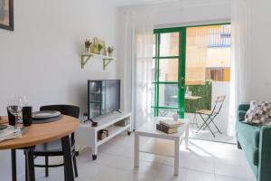 a living room with a table and a tv at Casa Frida with High-speed Wifi and Smart-TV in Corralejo