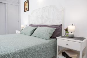a white bedroom with a bed and a white nightstand at Casa Frida with High-speed Wifi and Smart-TV in Corralejo