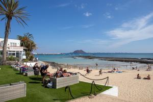 a group of people sitting on the beach at Casa Frida with High-speed Wifi and Smart-TV in Corralejo