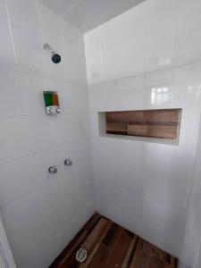 La salle de bains blanche est pourvue d'une douche et de parquet. dans l'établissement Nuevo Depa #7 tipo loft en Planta Alta en Centro Histórico, à Zacatecas