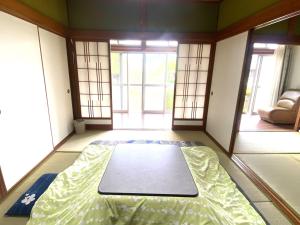 una camera con un letto nel mezzo di una stanza di 鉄道と山の見える家 a Yufu